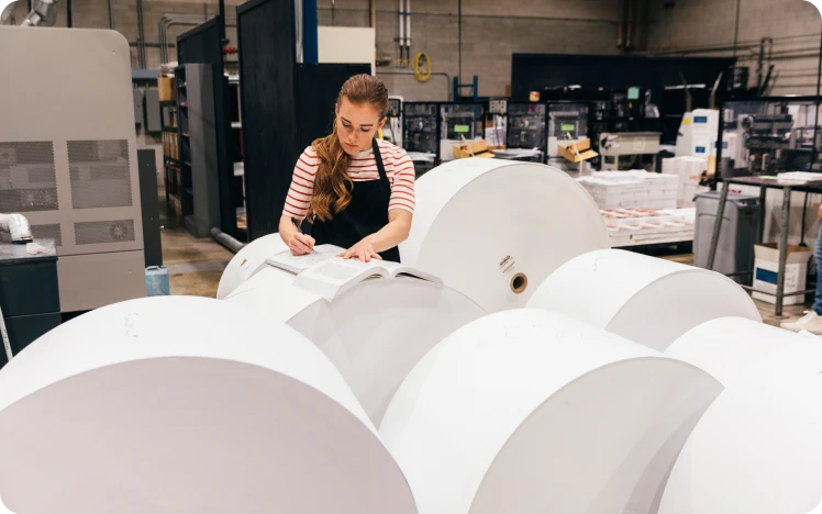 Worker inspecting paper in industrial setting